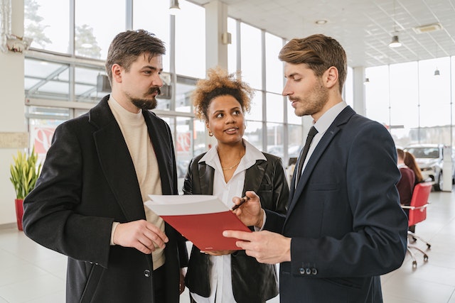 diverse couple looking over lease agreement with landlord